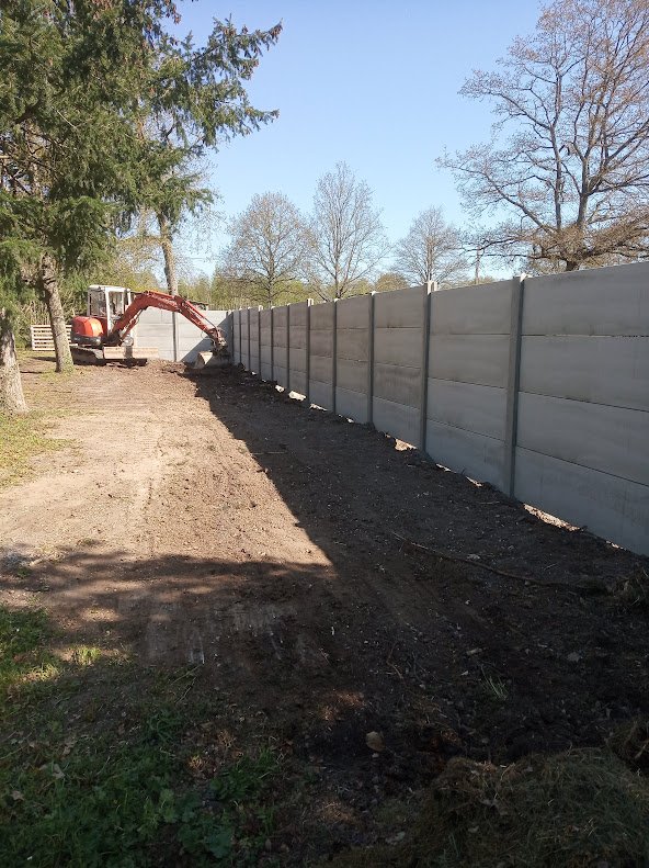 Clôture en plaques et poteaux béton posée sur un terrain préparé par JRTP