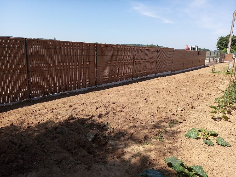 Clôture rigide avec lames occultantes brunes et soubassement béton installée par JRTP