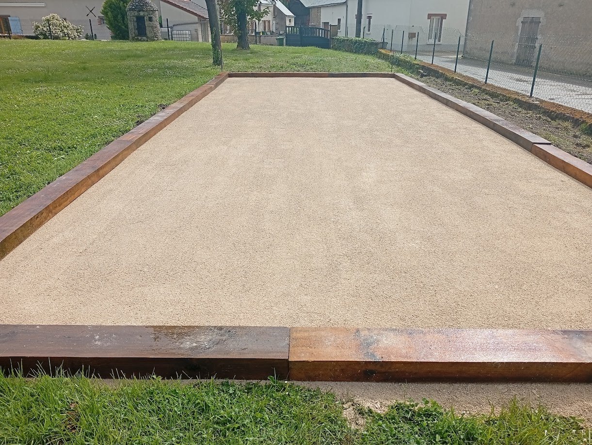 Terrain de pétanque bordé de bois aménagé dans un jardin par JRTP